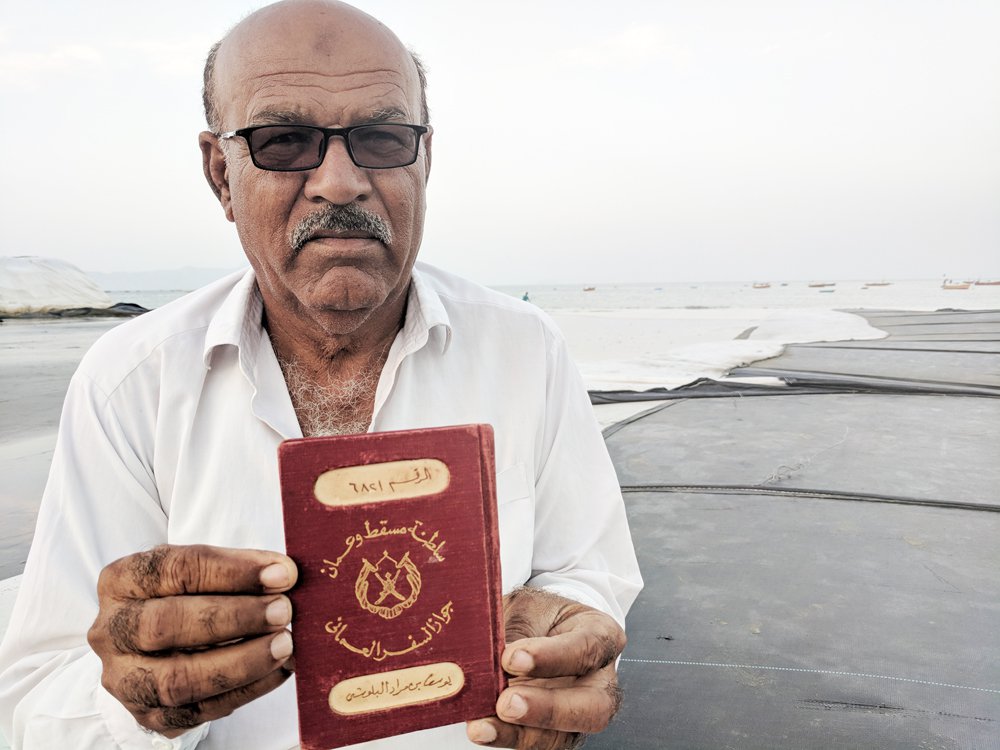 داد کریم اپنے والد کا عمانی پاسپورٹ دکھا رہے ہیں۔ تصویر حسام لشکری/عرب نیوز